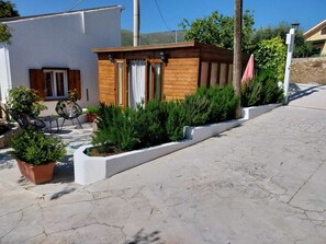A modern building with a wooden structure, potted plants, and outdoor seating. - Villa Lachesi surrounded by greenery c pool sauna and barbeque between Palermo and Cefalù (Caccamo)