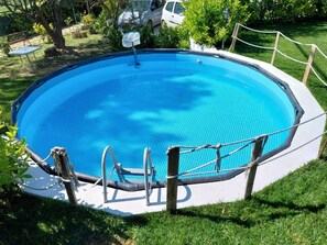 A round above-ground swimming pool with a safety ladder and rope barrier. - Villa Lachesi surrounded by greenery c pool sauna and barbeque between Palermo and Cefalù (Caccamo)