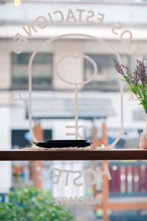A decorative metal frame with the text "ESTACIONADO 20" and "HOTEL" on a shelf. - Hostel Dos Estaciones (Alicante)