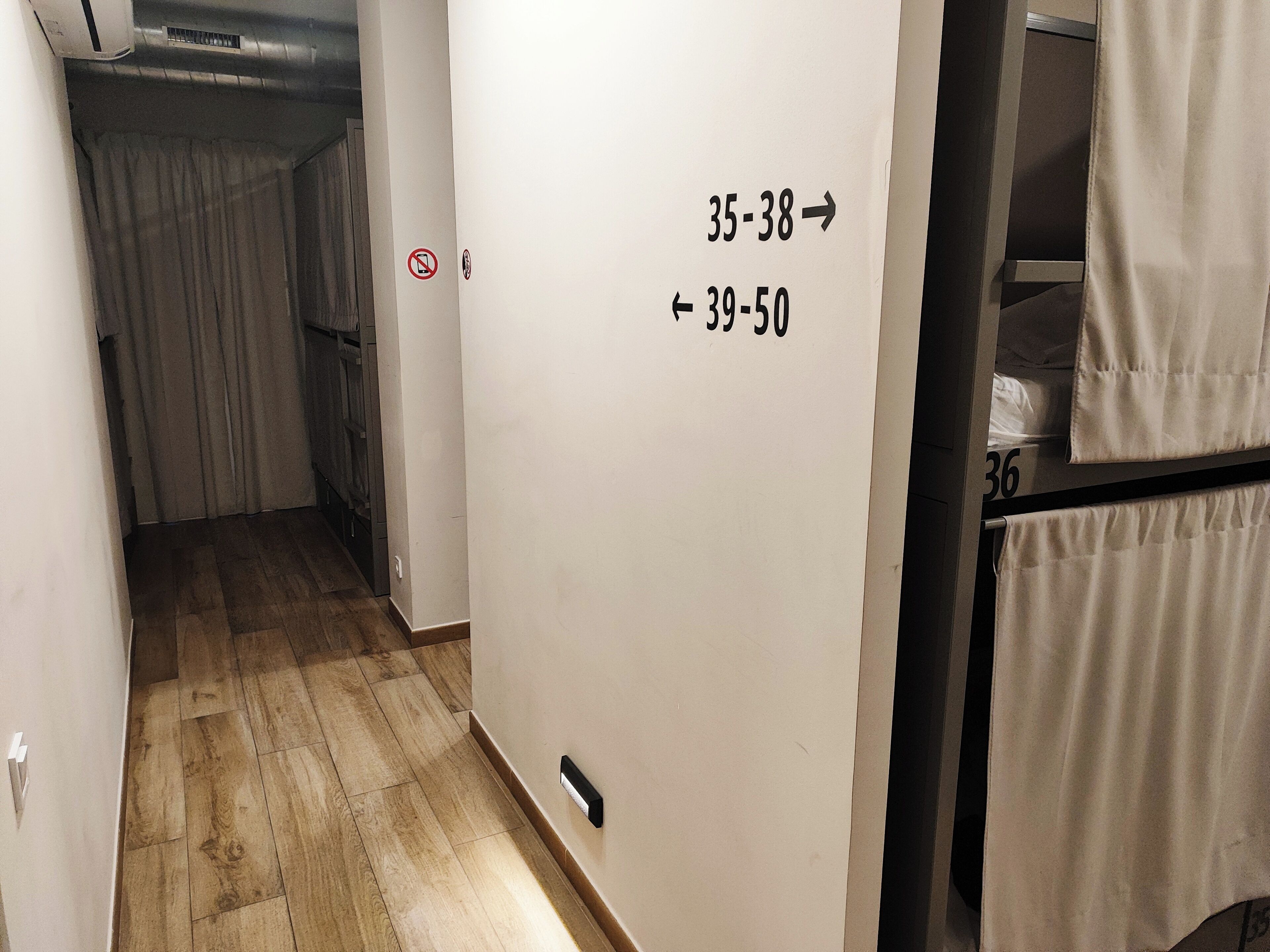 Un pasillo con un cartel que indica las habitaciones 35 al 38 y 39 al 50.