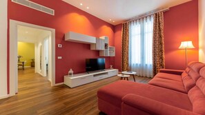 A modern living room with a flat-screen TV, a sofa, and a small table. - Solemar Sicilia - Baciamo le mani (Palermo)