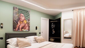 Ein Schlafzimmer mit Bett, einem Gemälde, einem Kleiderschrank und einem Spiegel.