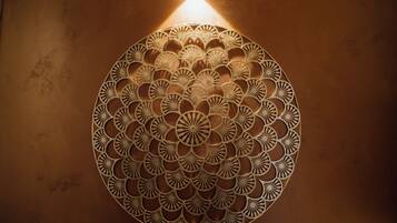 Un mur orné d’un motif géométrique et symétrique, éclairé par une source de lumière.