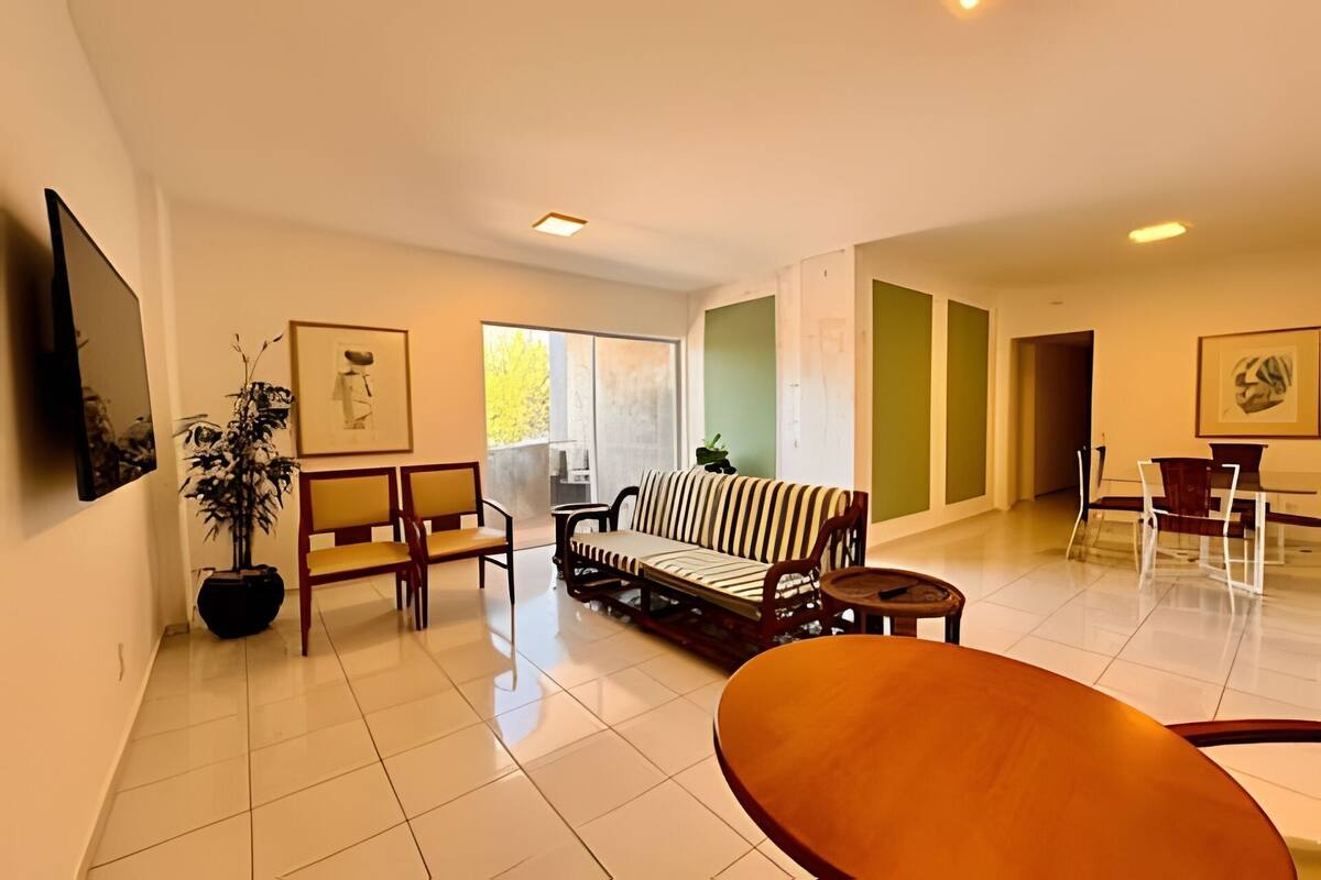 Uma sala de estar moderna com sofá, cadeiras, mesa de centro e obras de arte nas paredes.