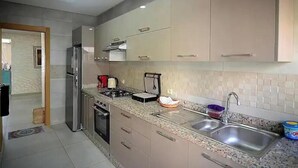 Een moderne keuken met een roestvrijstalen koelkast, een inbouwoven, een gasfornuis en een dubbele spoelbak.