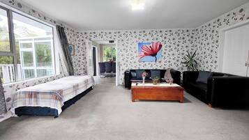Una sala de estar con cama, sofá, mesa de centro y comedor.