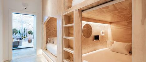 Ein modernes Hotelzimmer mit Holzwänden, einem großen Fenster und einem runden Oberlicht.