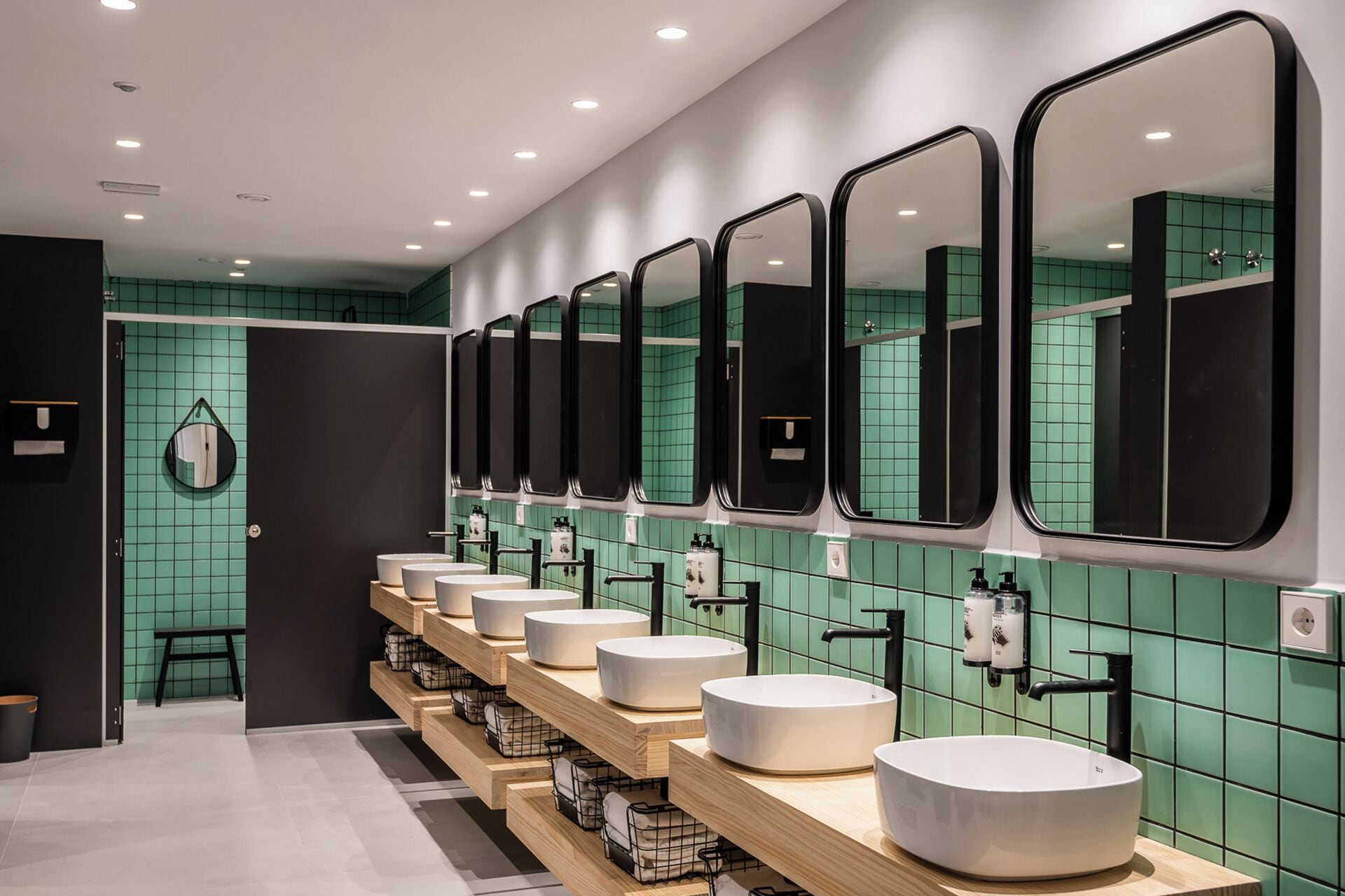 Un baño moderno con varios lavamanos y espejos.