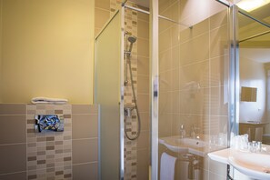 A modern bathroom with a glass-enclosed shower, a sink, and a mirror. - Hôtel - Restaurant La Caborne (Limonest)