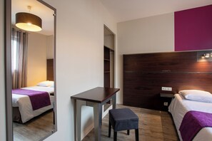 A hotel room with a bed, a desk, a chair, a mirror, and a wardrobe. - Hôtel - Restaurant La Caborne (Limonest)