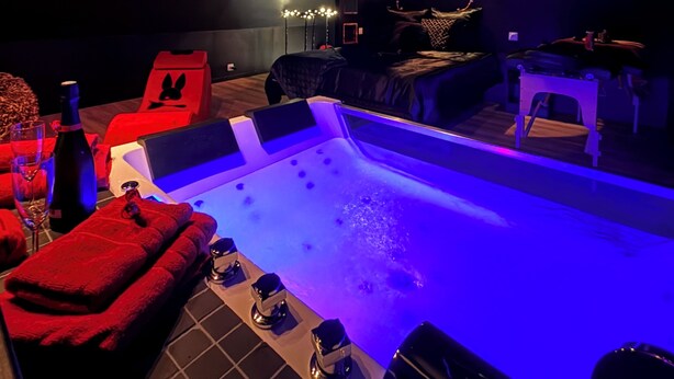 Un moderno espacio de spa con hidromasaje, asientos e iluminación ambiental.