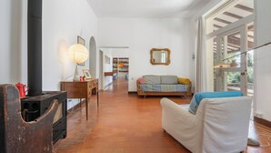 Un salon chaleureux avec une cheminée, un canapé et un coin repas à l’arrière-plan.
