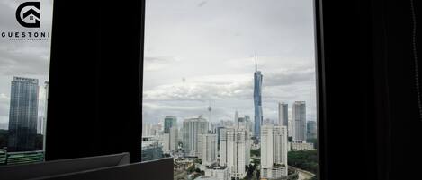 Vista de un paisaje urbano a través de una ventana con marco negro.