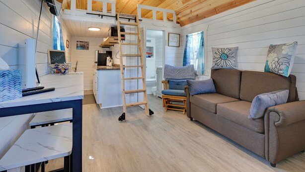 Een gezellig chaletinterieur met een vide, een bank, een eettafel en een keukenhoek.