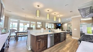 A modern kitchen with a central island, wooden cabinets, and pendant lighting. - LOWER Level of "Your Big Lake House" - Firepit, Kayaks, HotTub, etc.  (Cedar Bluff)