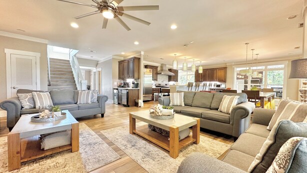 A spacious living area with a kitchen in the background, wooden flooring, and a ceiling fan. - LOWER Level of "Your Big Lake House" - Firepit, Kayaks, HotTub, etc.  (Cedar Bluff)