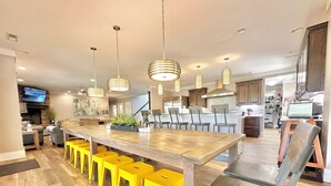 A modern kitchen with a central island, bar stools, pendant lighting, and a television. - LOWER Level of "Your Big Lake House" - Firepit, Kayaks, HotTub, etc.  (Cedar Bluff)