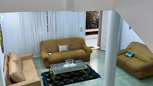 A living room with two sofas, a coffee table, and a patterned rug. - Dar khouaja

 (Mahdia)