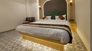 Une chambre à coucher bien rangée, avec un grand lit, une table de chevet et une chaise.