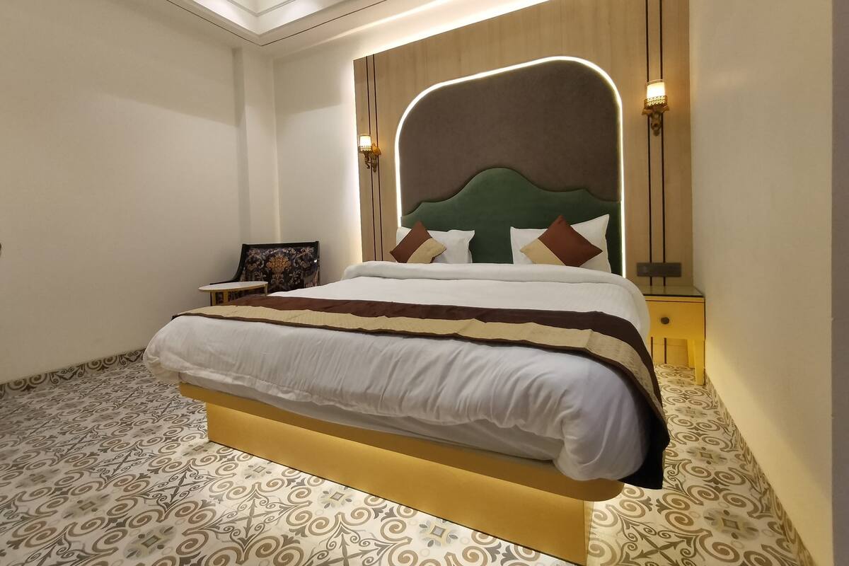 A neatly arranged bedroom with a large bed, a side table, and a chair.