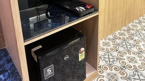 Une petite cuisine équipée d’une machine à café, d’une bouilloire et d’un petit réfrigérateur.