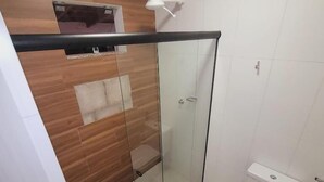 Ein modernes Badezimmer mit Duschkabine, Toilette und Waschbecken.