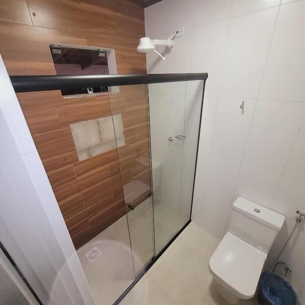 A modern bathroom with a glass shower enclosure, a toilet, and a sink. - Hilton Hotel (Aragarcas)