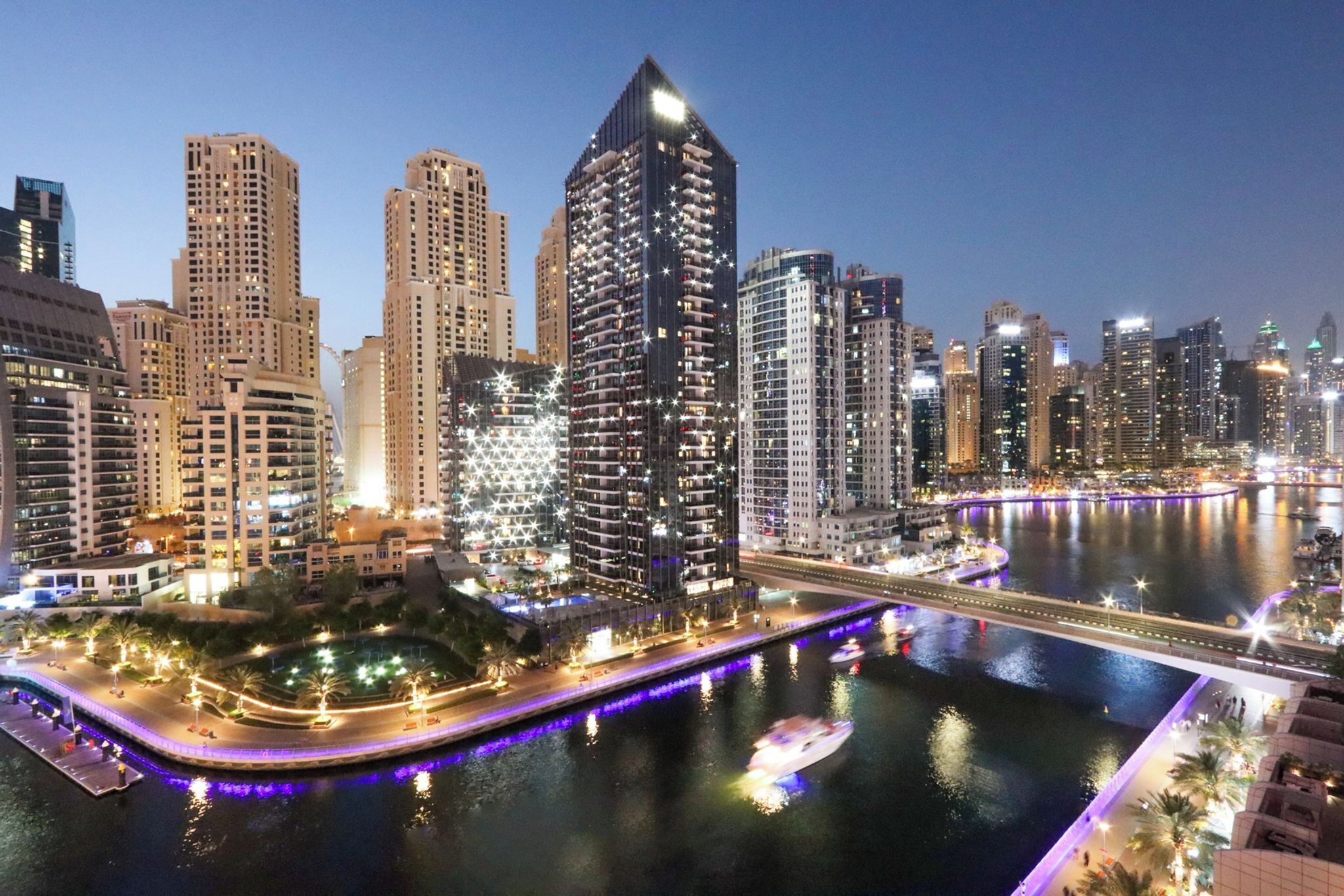 A cityscape with high-rise buildings, a river, and a bridge.