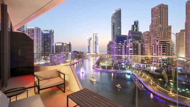 A balcony with a view of a cityscape and a river. - Deluxe 1BR Corner Suite with Marina Views (Dubai)