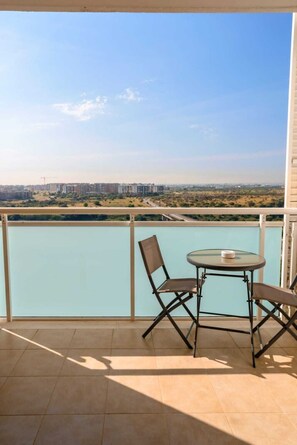 A balcony with a table and chairs, overlooking a cityscape and a body of water. - LUXURY 1 (Bari)