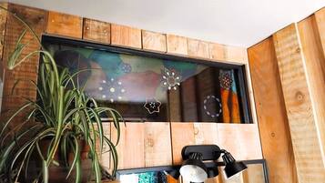 Une pièce aux murs recouverts de lambris en bois, avec une plante en pot et une œuvre d’art encadrée.
