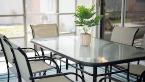 Une table de conférence entourée de chaises, une plante en pot et une vue dégagée sur l’extérieur grâce à de grandes fenêtres.