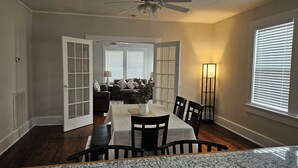A dining area with a table set for four, a ceiling fan, and a floor lamp. - Cozy Historic Home just 2 miles from USC, downtown and 6 miles from Ft. Jackson (Columbia)