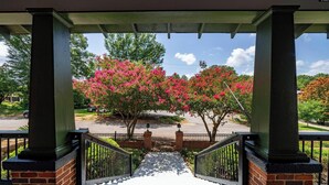A covered porch with brick columns and a gated entrance leading to a parking area. - Cozy Historic Home just 2 miles from USC, downtown and 6 miles from Ft. Jackson (Columbia)