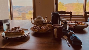A breakfast table with pastries, a teapot, a coffee pot, and a bowl of fruit. - Maison LGBT des Monts Bleus (Moissac-Vallee-Francaise)