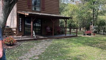 A rustic wooden building with a porch and a 'Welcome' sign.