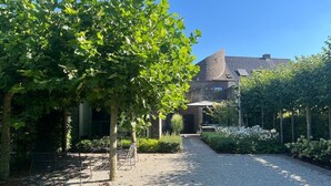 Ein Garten mit einem Kiesweg, der zu einem Gebäude mit einem Ziegeldach führt.