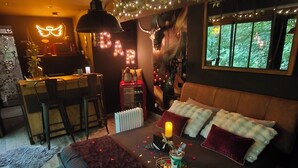 A cozy bedroom with a bed, bedside table, and a desk area with a chair. - L'Ange De Fer (immersion totale en pleine forêt) (Illoud)