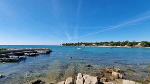 A coastal marina with boats docked, clear blue water, and a rocky shoreline. - Special holiday home only 50 metres to the beach with BBQ, sea view, parking space (Lovrecica)