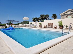 A swimming pool with lounge chairs and umbrellas, surrounded by a stone wall and palm trees. - Special studio flat in a stone house with pool, air conditioning, WiFi (Novigrad)
