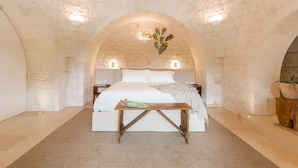 Ein gemütliches Schlafzimmer mit einem großen Bett, einem Nachttisch aus Holz und einem kleinen Tisch.