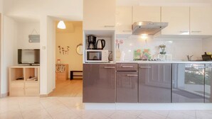 Uma cozinha moderna com micro-ondas embutido, eletrodomésticos de aço inoxidável e uma grande janela com vista para a cidade.