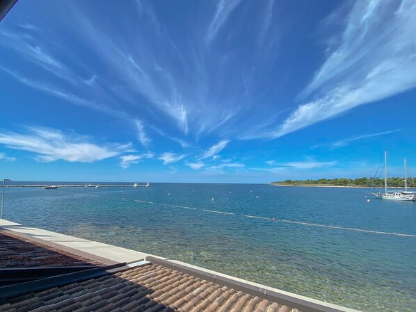 A clear view of a marina with boats and a distant island. - Breathtaking sea views and only 30 metres to the beach (Novigrad)