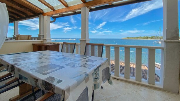 A covered outdoor dining area with a view of the sea and a distant island. - Breathtaking sea views and only 30 metres to the beach (Novigrad)