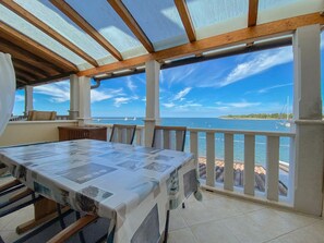 A covered outdoor dining area with a view of the sea and a distant island. - Breathtaking sea views and only 30 metres to the beach (Novigrad)
