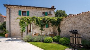 Un bâtiment en pierre doté d’un jardin, d’un foyer et d’un petit espace extérieur aménagé pour s’asseoir.