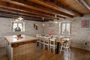 Rustic kitchen with a central island and sink, surrounded by comfortable seating and natural light.
