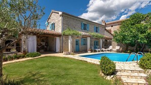 A stone villa with a swimming pool, a covered patio, and a well-maintained garden. - Mediterranean stone house with private pool, sauna, sea view, summer kitchen (Sveti Lovrec)