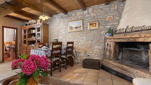 A rustic interior with a stone wall, wooden furniture, a fireplace, and a dining area. - Mediterranean stone house with private pool, sauna, sea view, summer kitchen (Sveti Lovrec)