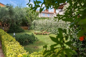 Relax on a wooden bench amidst lush greenery and vibrant flowers in a serene garden setting.